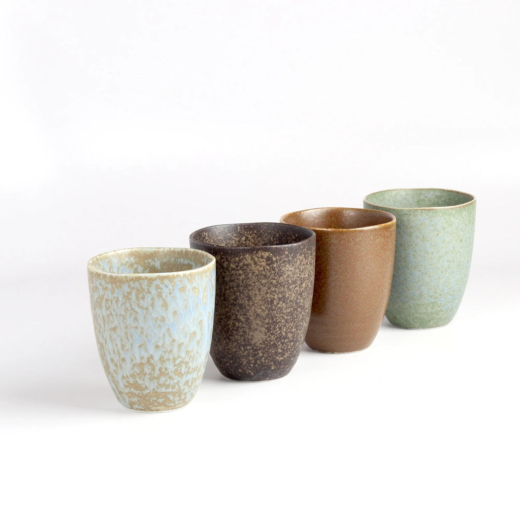 A set of four (4) Japanese ceramic mugs on white background in blue, brown and greenish blue.