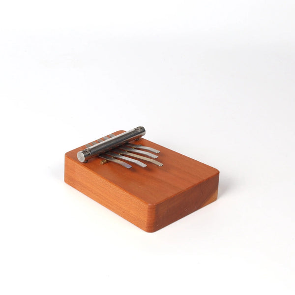 Small kalimba with five (5) metal tines on white background.