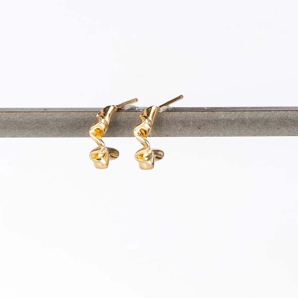 Ruffle Huggie Earrings by Kaylin Hertel on white background are perfectly minimal and pleated gold hoop earrings in 14k yellow gold with post closure.