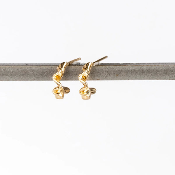Ruffle Huggie Earrings by Kaylin Hertel on white background are perfectly minimal and pleated gold hoop earrings in 14k yellow gold with post closure.