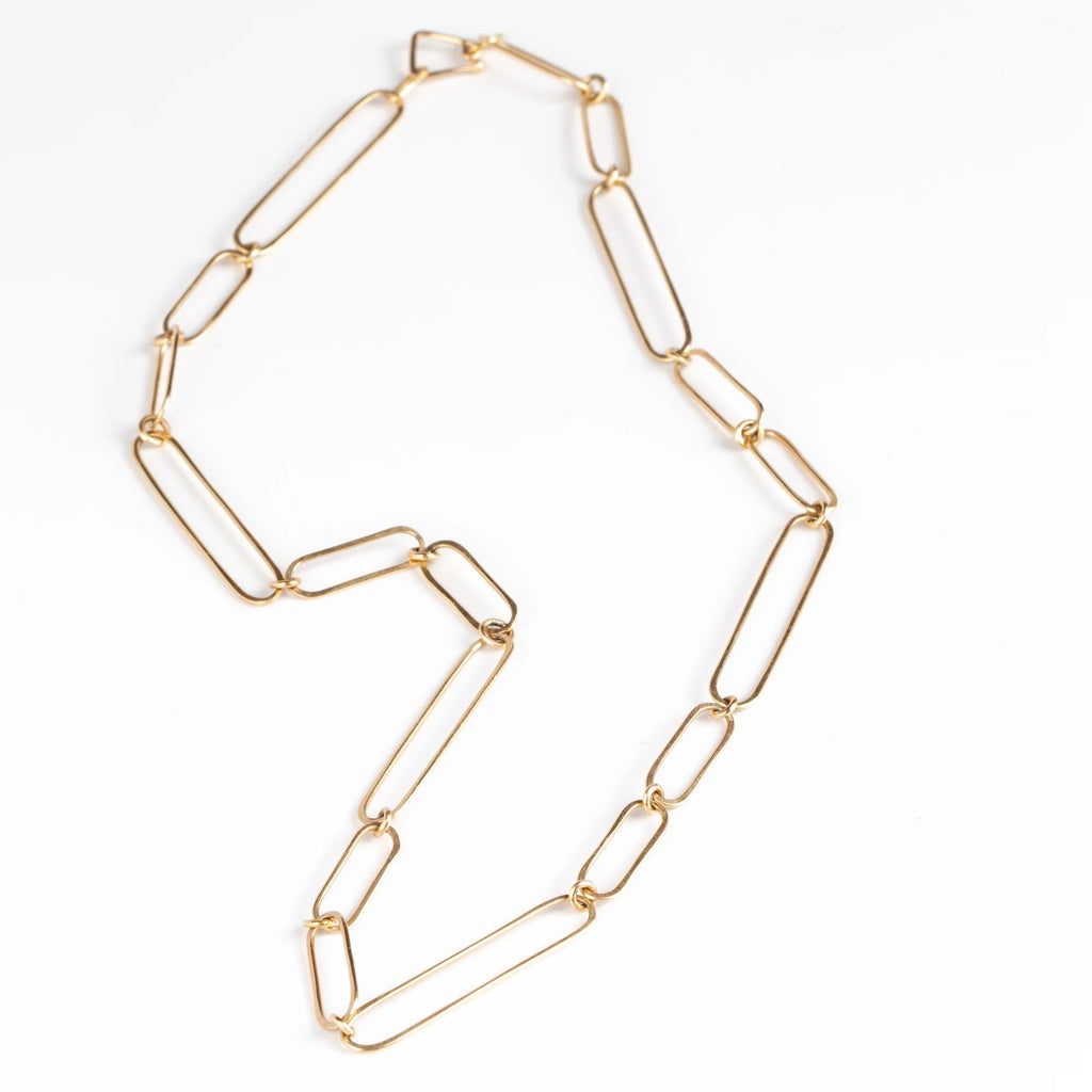 Short 14k gold paperclip chain necklace with two short, one long flat clips in 15 inches by Kaylin Hertel on white background.