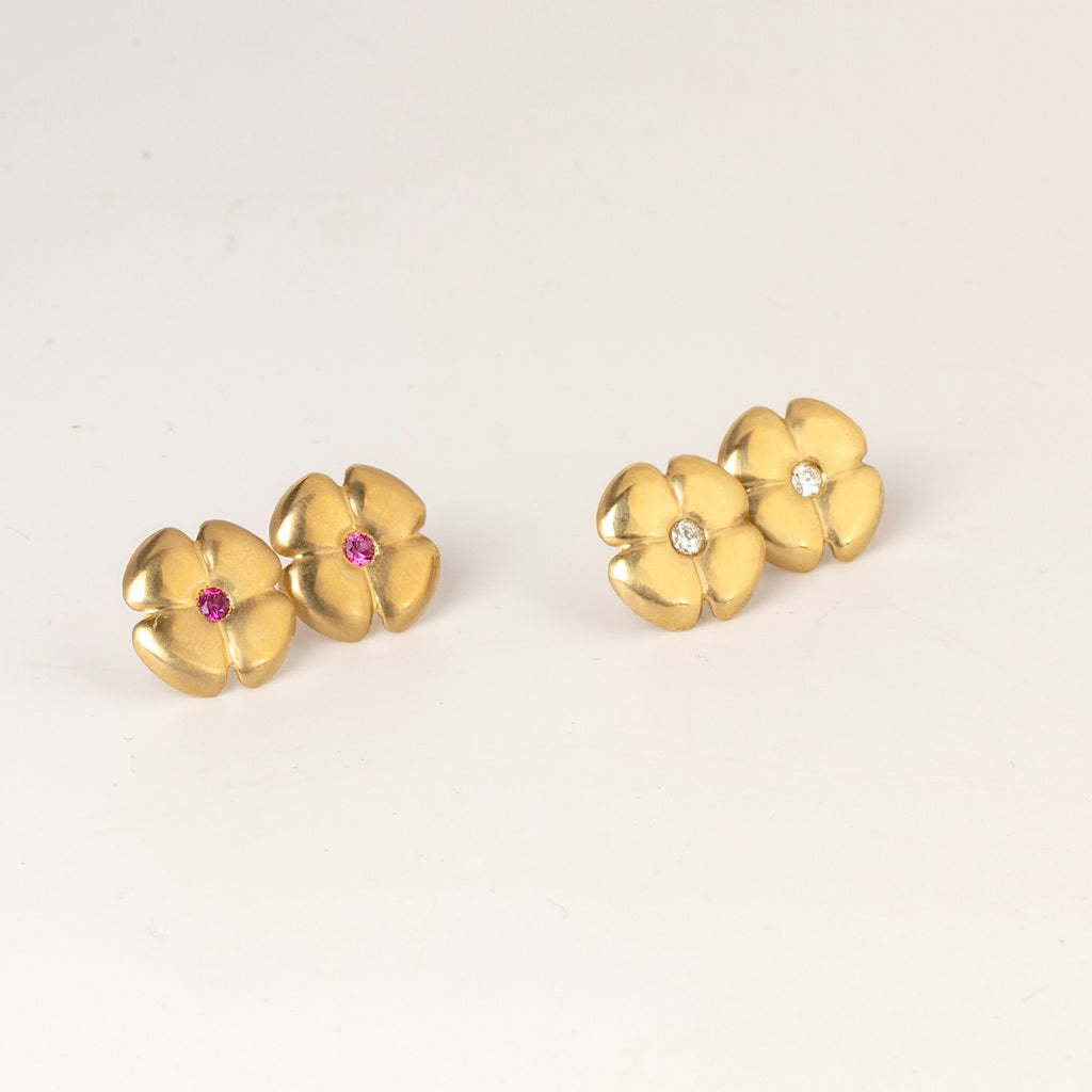 Large flower stud earrings by Kaylin Hertel  on white background shown in white diamond and magenta pink sapphire in 14k gold .