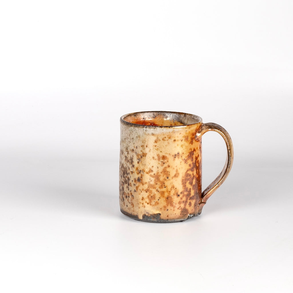The LO mug is a wood fired ceramic mug by Lindsey Oesterritter. Wood ash in the kiln results in highly varying surfaces so each one unique and one of a kind. This one is number 5.