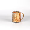 The LO mug is a wood fired ceramic mug by Lindsey Oesterritter. Wood ash in the kiln results in highly varying surfaces so each one unique and one of a kind. This one is number 5.