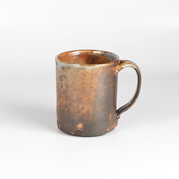 The LO mug is a wood fired ceramic mug by Lindsey Oesterritter. Wood ash in the kiln results in highly varying surfaces so each one unique and one of a kind. This one is number 1.
