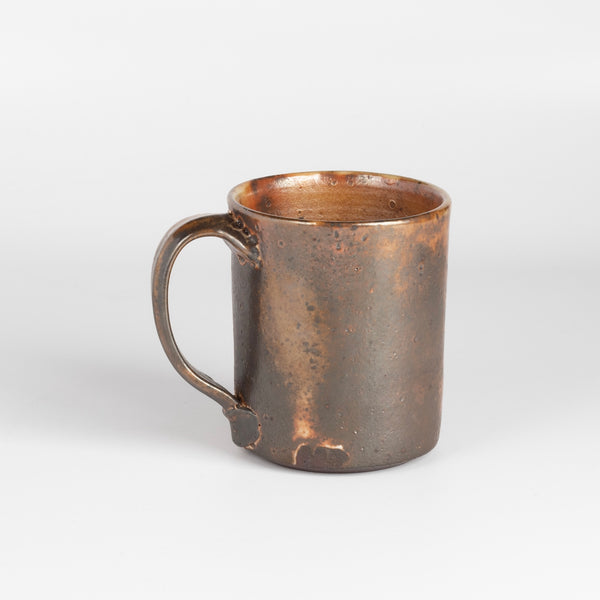 The LO mug is a wood fired ceramic mug by Lindsey Oesterritter. Wood ash in the kiln results in highly varying surfaces so each one unique and one of a kind. This one is number 1.
