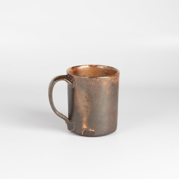 The LO mug is a wood fired ceramic mug by Lindsey Oesterritter. Wood ash in the kiln results in highly varying surfaces so each one unique and one of a kind. This one is number 1.