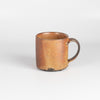 A wood fired  ceramic mug by master of wood fired ceramics, Lindsay Oesterritter. Wood ash in the kiln results in highly varying surfaces so each mug is unique,. As beautiful as they are functional. Sizes vary slightly, glazes considerably. One of a kind.