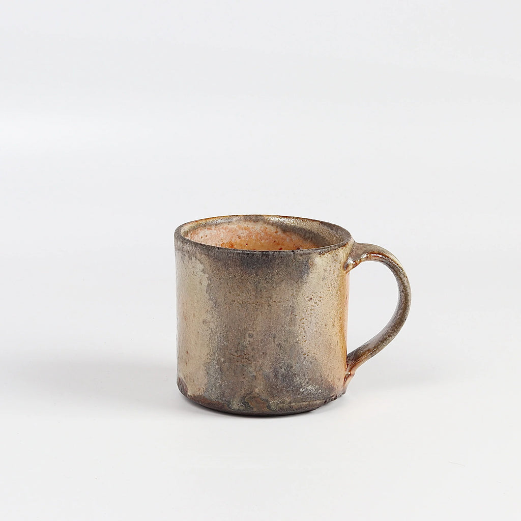 The LO mug is a wood fired ceramic mug by Lindsey Oesterritter. Wood ash in the kiln results in highly varying surfaces so each one unique and one of a kind. This one is number 3.