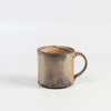 The LO mug is a wood fired ceramic mug by Lindsey Oesterritter. Wood ash in the kiln results in highly varying surfaces so each one unique and one of a kind. This one is number 3.