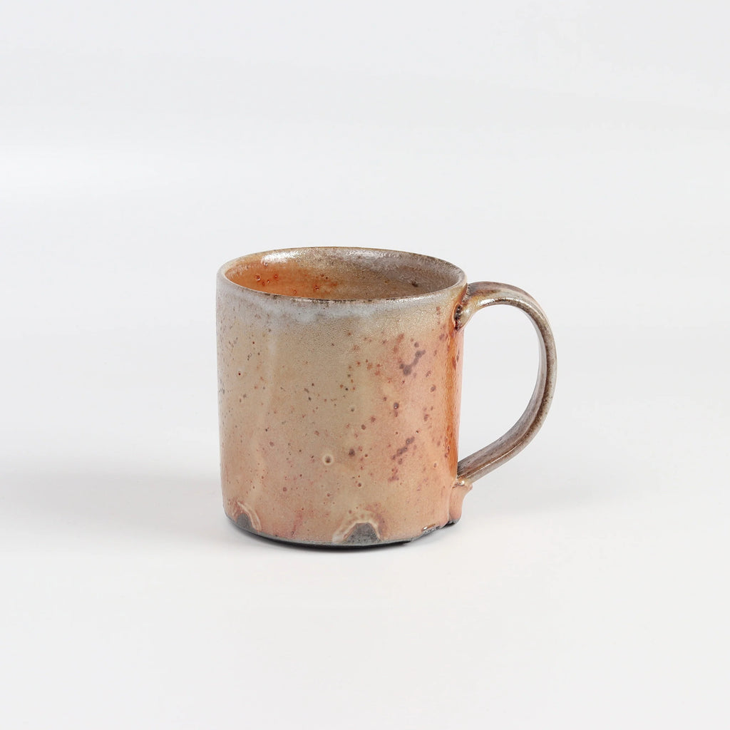 The LO mug is a wood fired ceramic mug by Lindsey Oesterritter. Wood ash in the kiln results in highly varying surfaces so each one unique and one of a kind. This one is number 4.