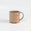 The LO mug is a wood fired ceramic mug by Lindsey Oesterritter. Wood ash in the kiln results in highly varying surfaces so each one unique and one of a kind. This one is number 4.