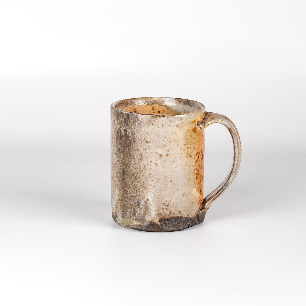 The LO mug is a wood fired ceramic mug by Lindsey Oesterritter. Wood ash in the kiln results in highly varying surfaces so each one unique and one of a kind. This one is number 1.