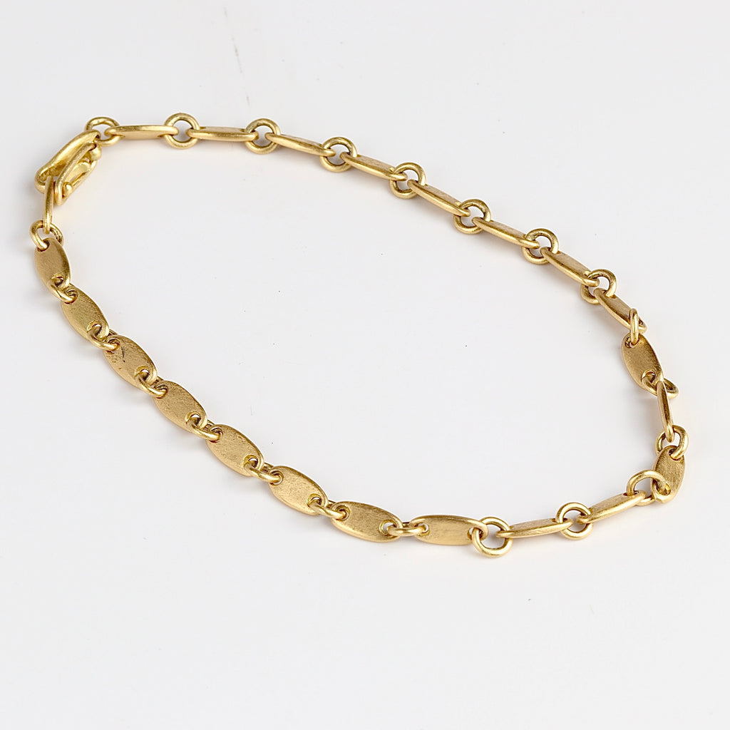 Rain Chain Short Line Bracelet by Marian Maurer in 18k yellow gold on white background.