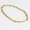 Rain Chain Short Line Bracelet by Marian Maurer in 18k yellow gold on white background.