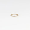 1mm thick diamond porch band by Marian Maurer on white background. This is a wedding band in bezel set round diamonds.