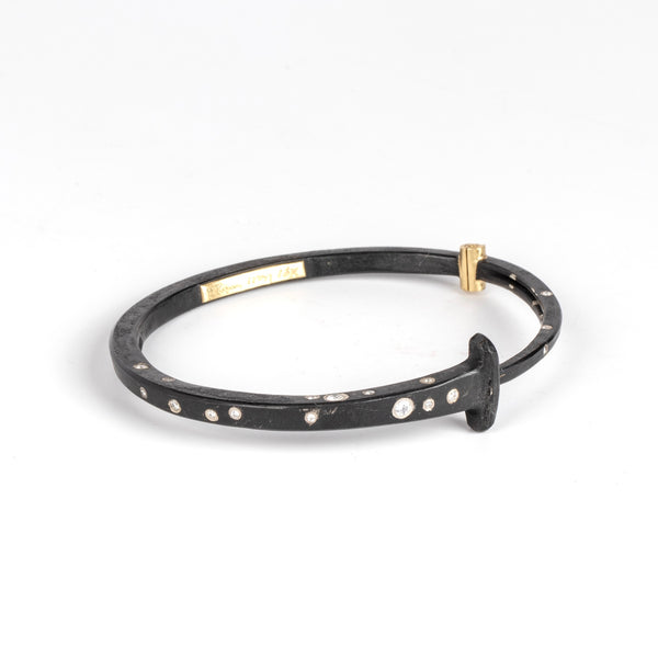 Nail Bracelet 1/3 ct Top Sprinkle by Pat Flynn is a forged iron bangle or cuff-like bracelet in the shape of a nail with a scattering of white diamonds and 18k gold  hinge. 