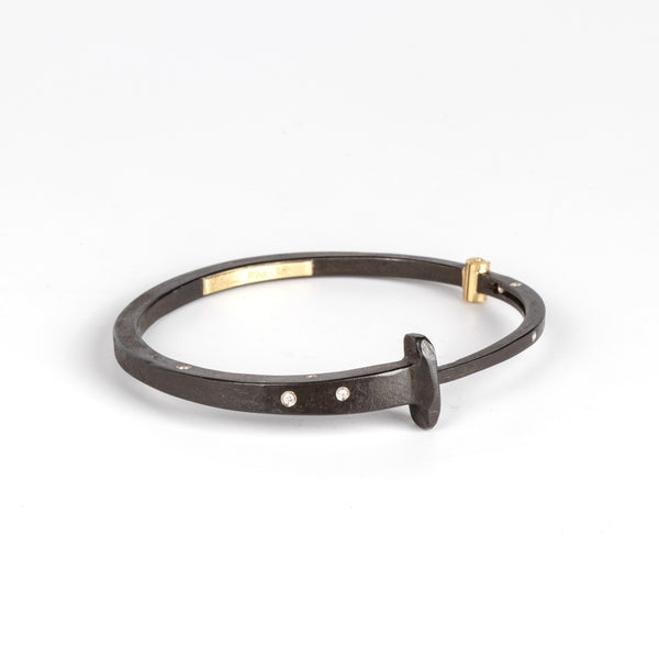 A Forged nail bracelet with nine scattered accent diamonds and completed with an 18k gold hinge and ball catch closure by Pat Flynn. 
