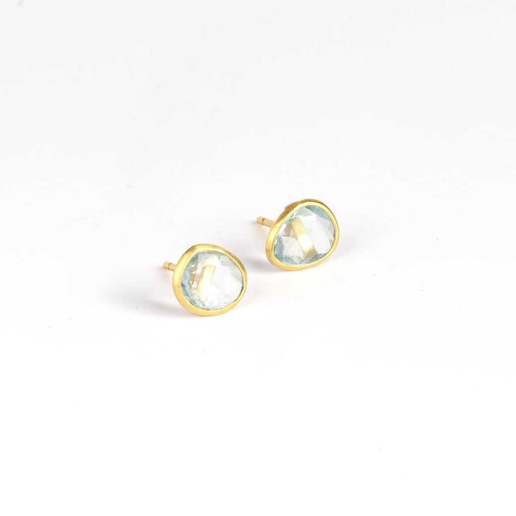 Angled view of Pippa Small Classic Stud studs earrings in aquamarine and 18k yellow gold on white background.