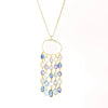 Raincloud Pendant Necklace by Pippa Small is a Large, faceted and transparent aquamarine with five rows of five stones each in blue to light purple hued tanzanite, aquamarine and kyanite bezel set stones in 18k yellow gold w extra long golden waxed cotton cord and accent bead for draping over head and no clasp.