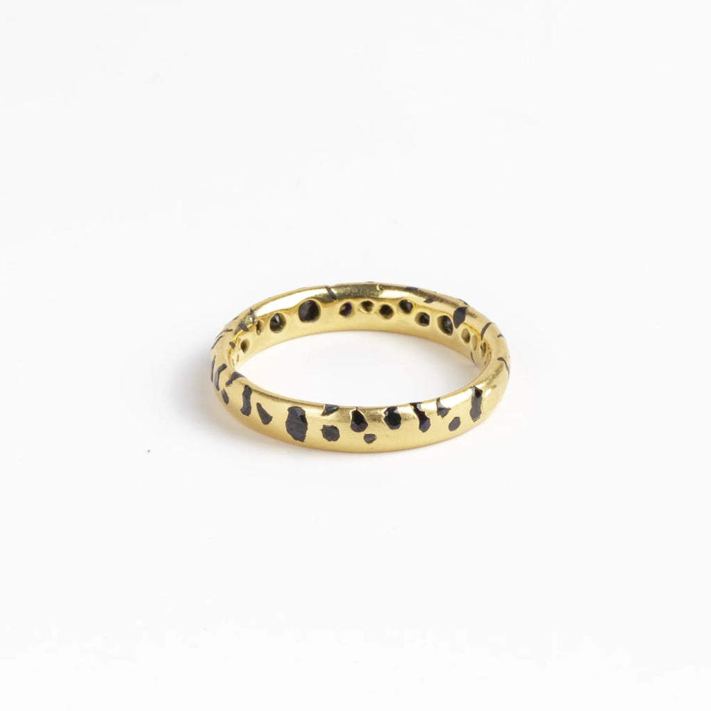 The Black Sapphire Confetti Band in size 8 designed by Polly Wales is a narrow 18k gold wedding band/ring speckled with black sapphires around the circumference. Cast not set. Made in Los Angeles. 