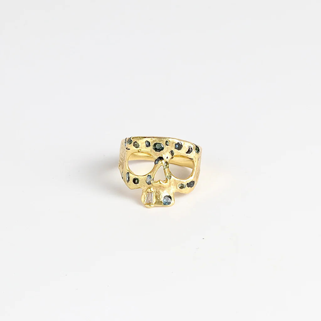 Stoned Mini Snaggle Tooth Skull ring by Polly Wales with green sapphires and a baguette diamond snaggle tooth.