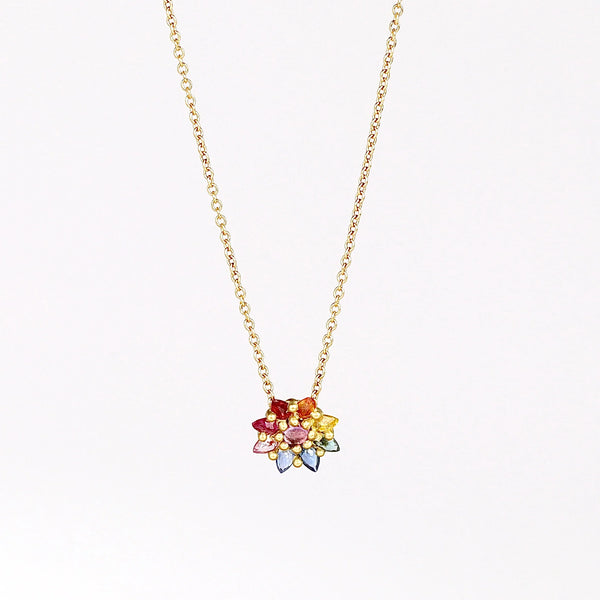 Daisy necklace in Rainbow by Polly Wales with pink cabochon center and rainbow  inverted and encrusted brilliant sapphires in hot pink, pink, lilac, blue, orange, green, and yellow. 