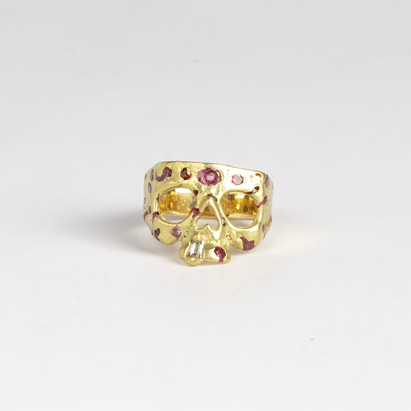 Mini Confetti Skull Plum Blossom signet ring by Polly Wales is a mini version of her confetti style squared 18k yellow gold skull ring with one white diamond baguette snaggletooth and a scattering of plum sapphires. Recycled gold. Cast in Place. Cast not set. Handmade in Los Angeles.
