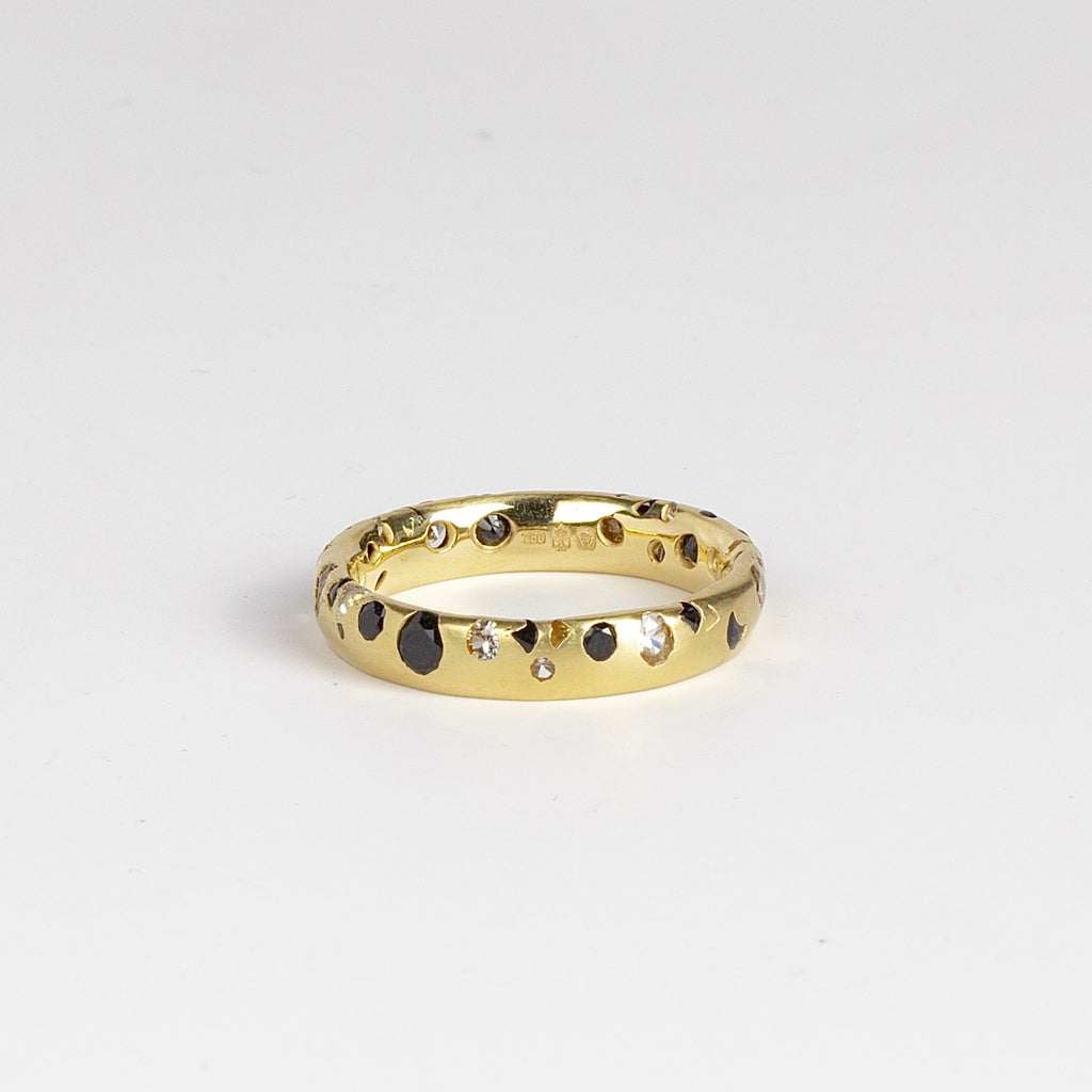 Black and White Confetti Band by Polly Wales is a narrow 18k yellow gold band with speckled black and white sapphires around the circumference for a beautiful confetti-like appearance. Recycled gold. Cast not set. Handcrafted in Los Angeles. Sie 6.5 n stock