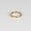 The Cornflower Blue Sapphire Confetti Band designed by Polly Wales is a narrow 18k yellow recycled gold wedding band/ring with speckled ombre light blue sapphires around the circumference. It is cast not set and handmade in Los Angeles.
