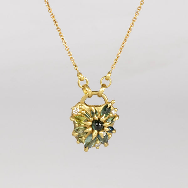 Green Fantaisie Encrusted Padlock Necklace by Polly Wales is a padlock in 18K yellow gold and encrusted with mixed green sapphires, a center cabochon and an accent diamond hanging on a chain that attaches to the lock handle by pulling the lever. Recycled gold. Cast in Place. Cast not set. Handmade in Los Angeles.