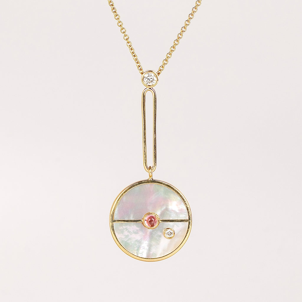 Compass Pendant in White Mother of Pearl and Pink Spinel is a unique modern take on an heirloom pendant. Stone inlay is accented with a center gem stone and white diamond. The compass hangs from an elongated paperclip link accented with a second white diamond. Handcrafted in Los Angeles.