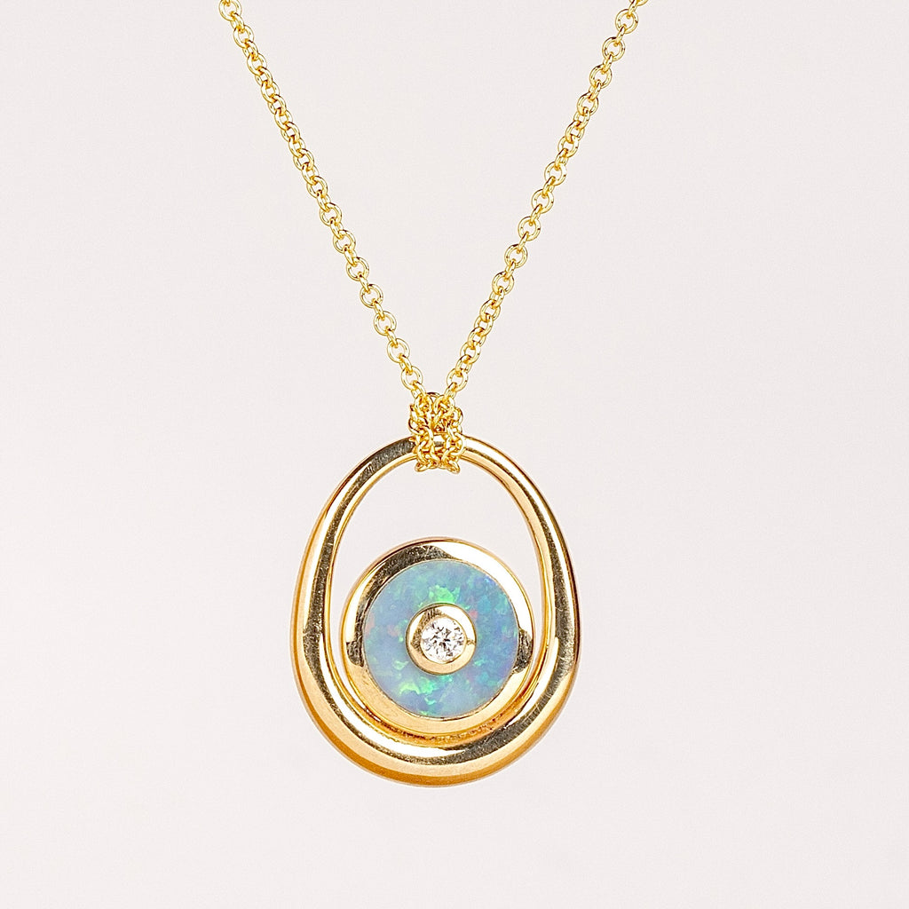 Midi Compass Sling Pendant w Opal by Retrouvai. A mini compass in opal stone inlay with a center diamond inside a 14k gold frame that hangs or is looped on a thin rolo chain. 