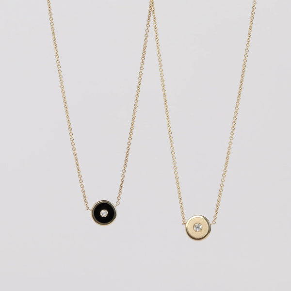 Mini Compass Pendant Necklace in Black Onyx and Brushed Gold by Retrouvai with a round white diamond center  accent on 16"  and 14k yellow gold chain on white background.