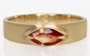 Studio shot on white of slim cigar band with sapphire.