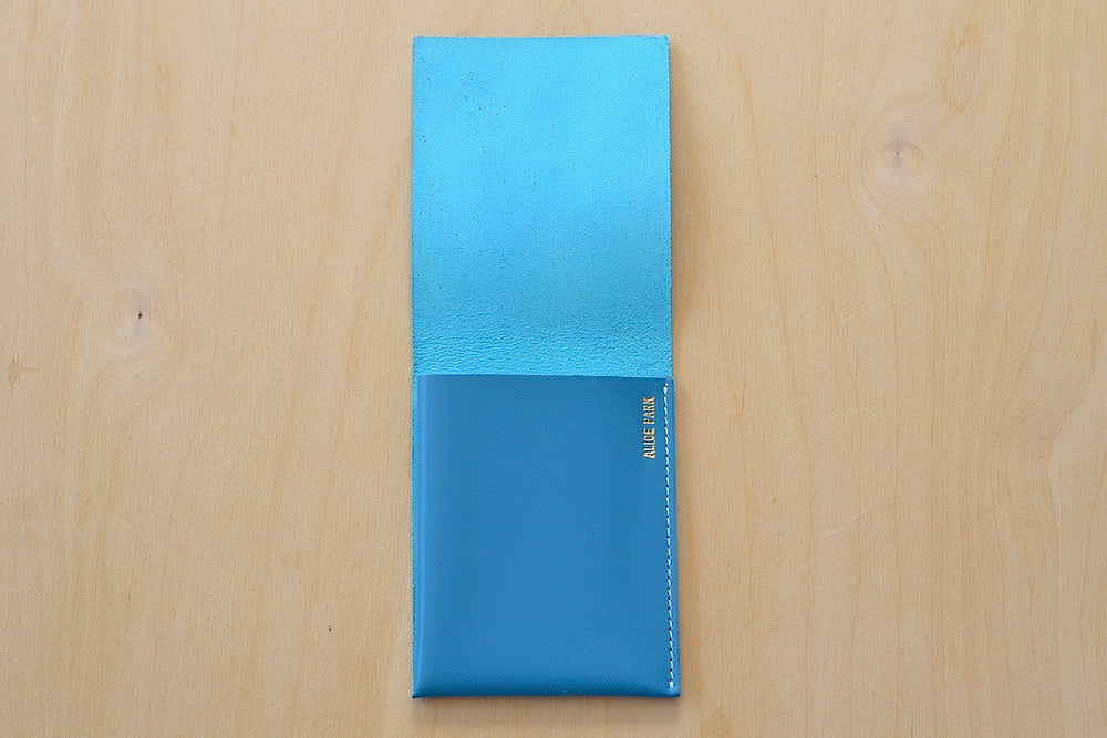 Simple Flap Wallet in Turquoise with white stitching shown open.