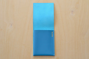 Simple Flap Wallet in Turquoise with white stitching shown open.