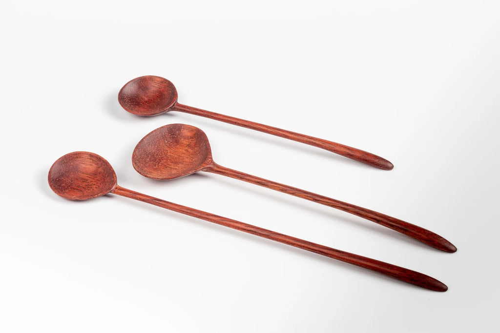 Close up of three hand carved wood spoons.