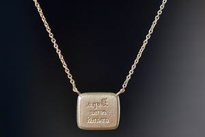 Reverse side of Makiko Wakita Lion and Mouse Duo Motto necklace reads “dopo come avanti” (‘after as forward’).