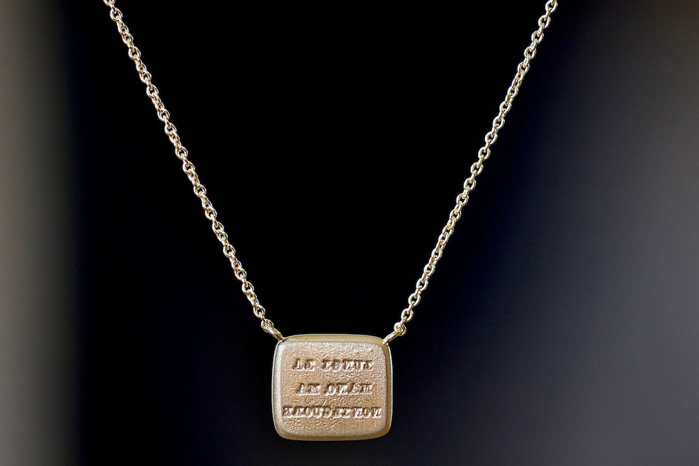 Back of Unconditional Motto Necklace designed by Makiko Wakita reads, "Lungi la mano ma non il cuore" (‘A far hand but not the heart’).