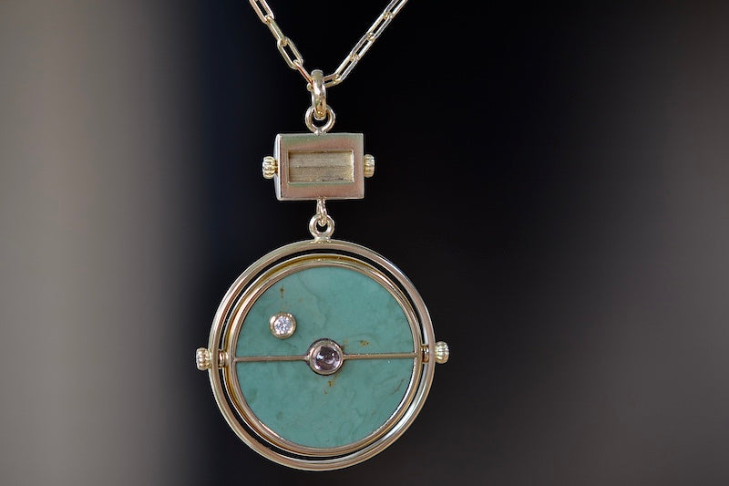 Back of  Grandfather Compass Pendant in Green Turquoise and Tanzanite by Retrouvai is a pendant necklace with stone inlay that is accented with a center gem stone in the front and back, and nine (9) round white diamonds.
