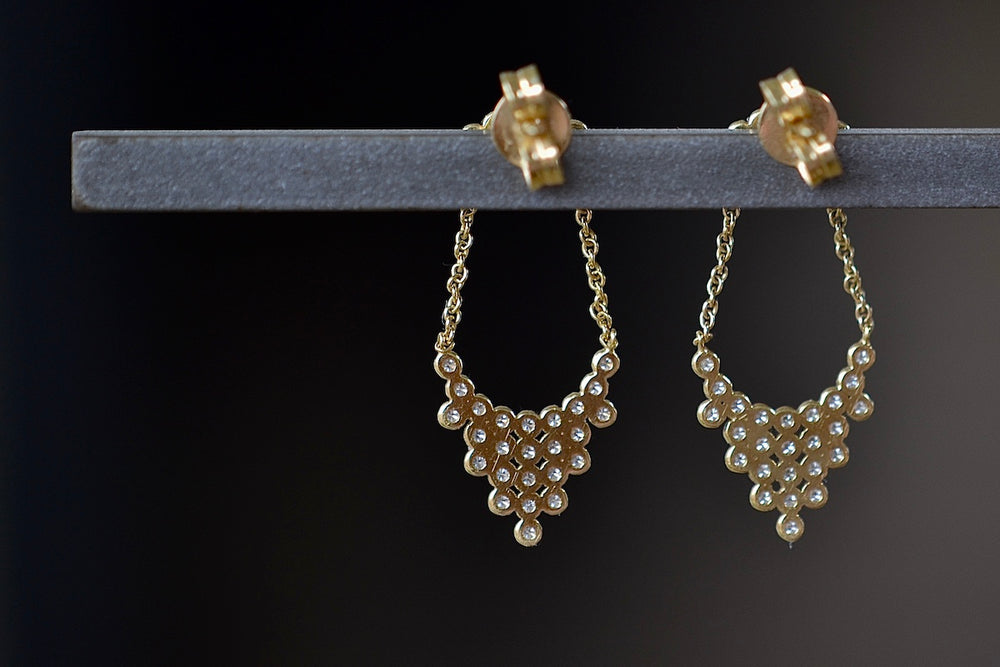 Back of Pétale Earrings by Yannis Sergakis are an arch of five bezel set and rhodium plated round cut diamonds with gold chains on each end hold together a cascade of twenty-five diamonds in a triangular shape to form a chandelier like earring on post closure in 18k gold. 