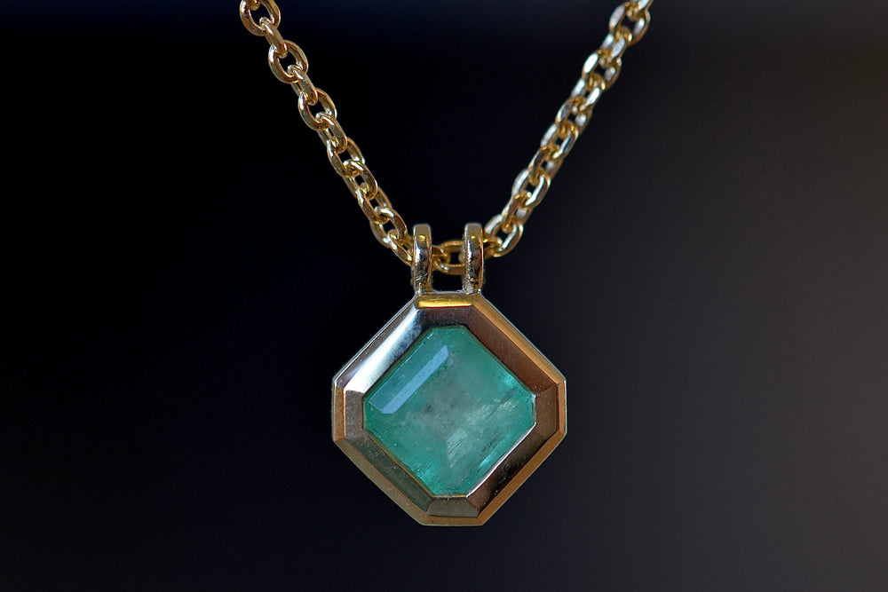 Close up of the Duo Bale Offset Emerald Necklace by Elizabeth Street Jewelry.