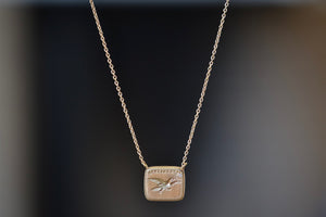 Fearless Duo Motto  Necklace with Diamond by Makiko Wakita is a flat disc in 18k yellow gold, stamped on the front and back. The image of an eagle soaring high in the sky with French words “Sans Crainte” ('Without fear' or' Fearless').
Symbolism/Meaning suggestion: In the old days the belief was that the eagle was the only animal that could look directly into the sun. It flies high, closer to the splendor of the sun. Soar to great heights without fear. Reach for your highest potential.