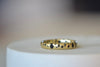The Black Sapphire Confetti Band in size 8 designed by Polly Wales is a narrow 18k gold wedding band/ring speckled with black sapphires around the circumference. Cast not set. Made in Los Angeles. 