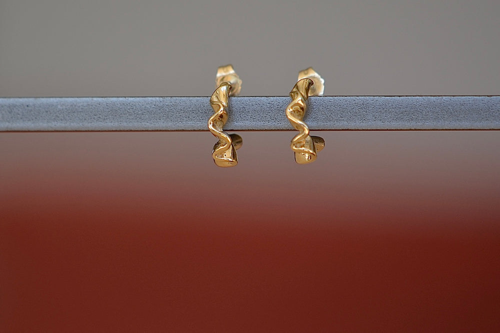 Squiggle Huggie Earrings by Kaylin Hertel arePerfectly minimal pleated and pleated gold ruffle huggie hoop earrings in 14k yellow gold with post closure.