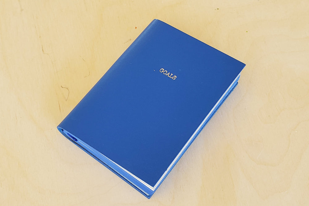 Leather Raw Edge Small Journal in blue with Goals printed on the front.