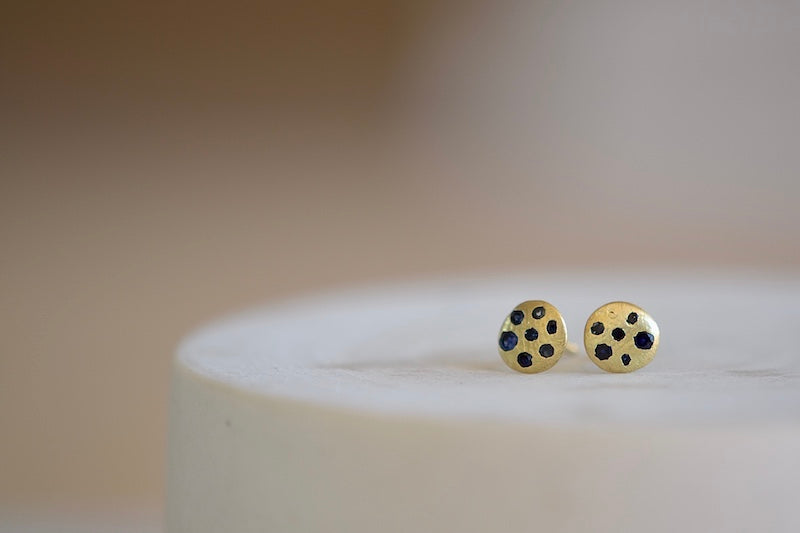 Polly Wales XS XSmall extra small Sandard Celeste Disc Stud Earrings in mid blue to navy Sapphires are classic, 18k recycled yellow gold disc earrings with blue in various shades sapphires, cast not set, cast in place and made in Los Angeles.