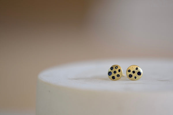 Polly Wales XS XSmall extra small Sandard Celeste Disc Stud Earrings in mid blue to navy Sapphires are classic, 18k recycled yellow gold disc earrings with blue in various shades sapphires, cast not set, cast in place and made in Los Angeles.