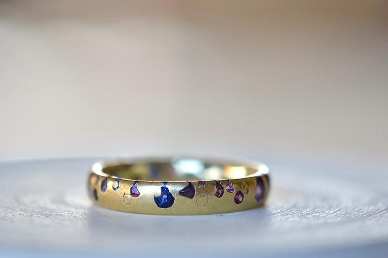 Alternate view of the Purple and Blue Sapphire Band Ring by Polly Wales is a narrow 18k yellow gold band with speckled purple, pink, blue to navy and black sapphires around the circumference for a beautiful confetti-like appearance. Recycled gold. Cast not set.